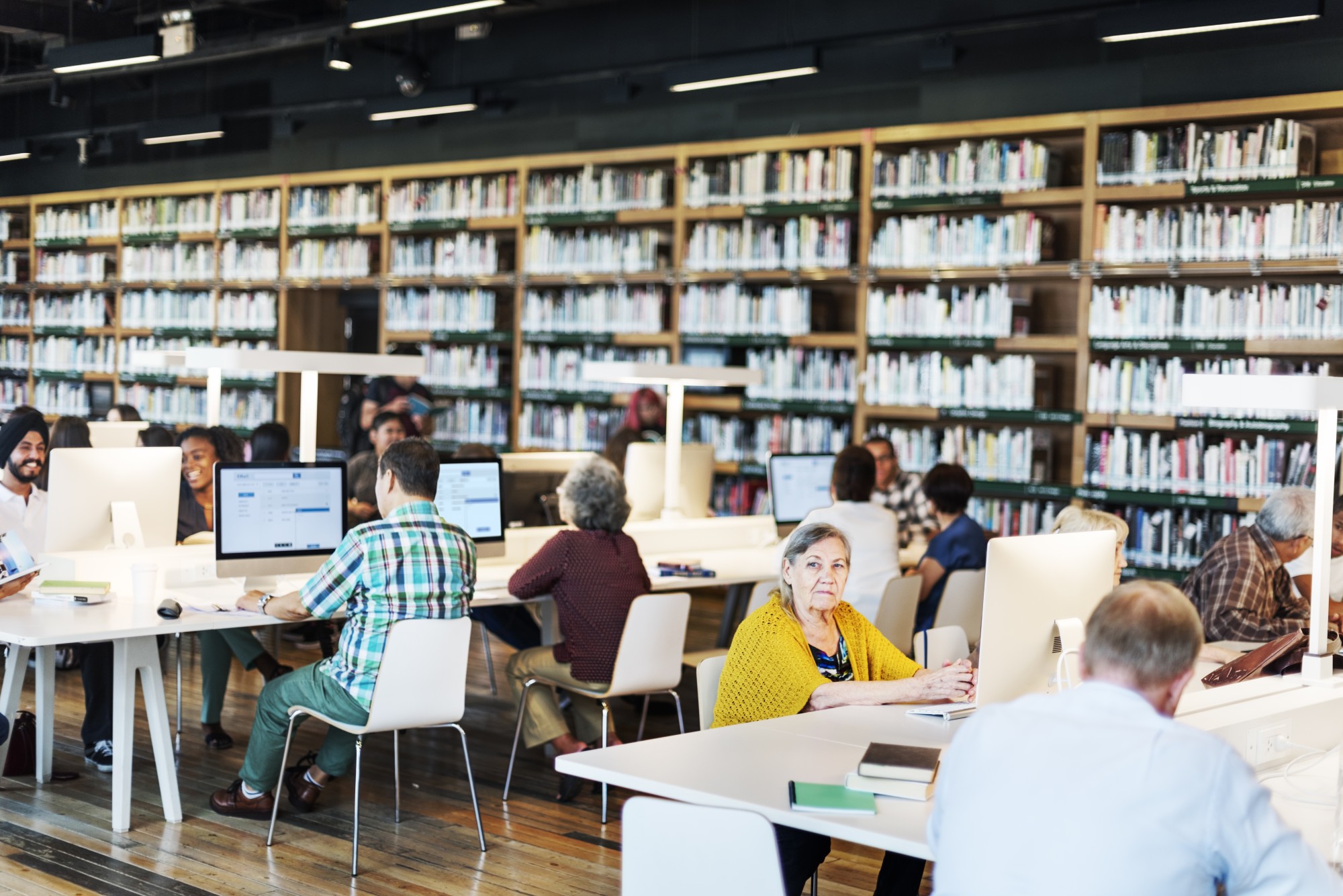 Library with books and people at computer desks